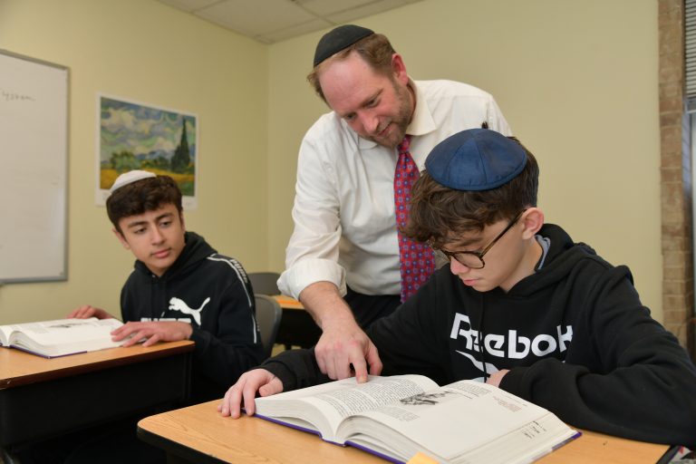 Students and a teacher learning at SINAI Maor High School